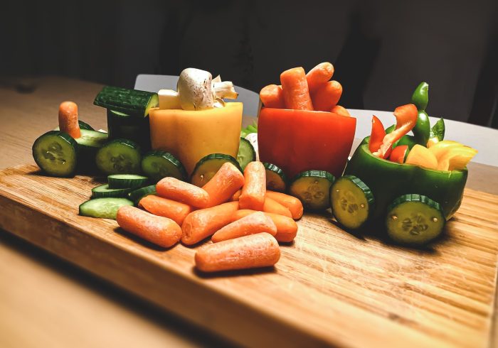 sliced carrots and green bell pepper on brown wooden chopping board