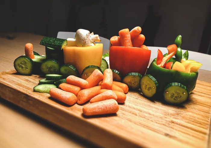 sliced carrots and green bell pepper on brown wooden chopping board